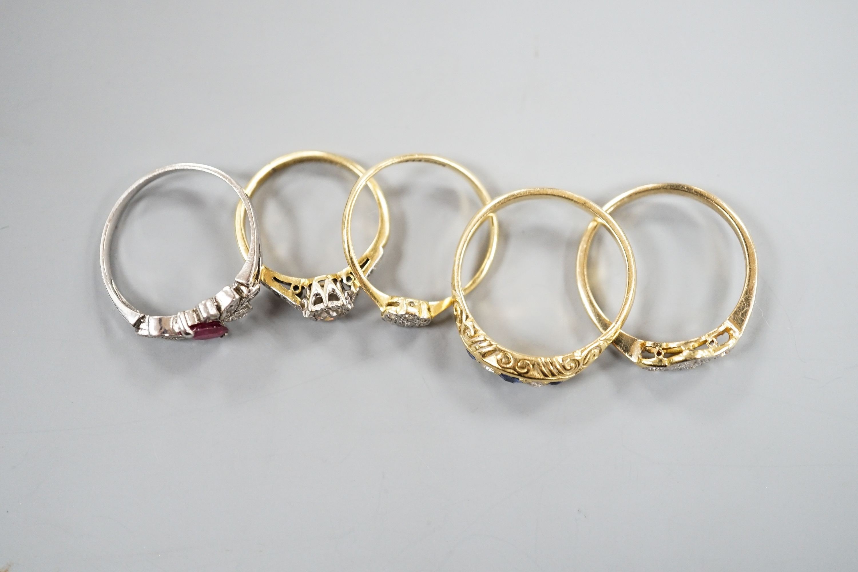 Two 18ct and diamond rings, including small cluster and single stone, sizes L & H, an 18ct sapphire and diamond ring, size O, gross 7.3 grams and two other yellow or white metal and gem set rings, gross 3.6 grams.